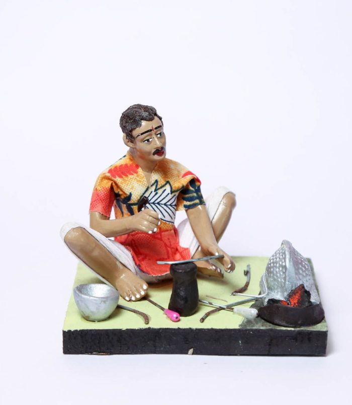 The-Indian-Blacksmith-Handmade-Decorative-Miniature-Clay-Figurine-WhiteBG-RainbowFeathers.jpg